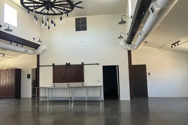 Event hall view showing sliding barn door pass-through and high vaulted ceiling