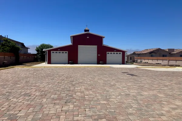 The Red Barn exterior — classic red barn with three bay doors and paved courtyard
